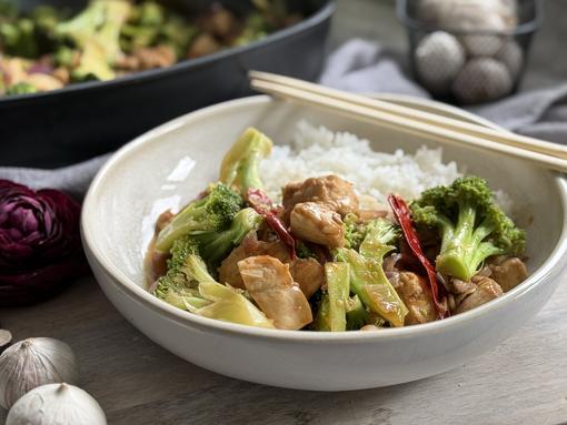 Asia-Hähnchen-Pfanne - Pampered Chef® Rezept Asia-Hähnchen-Pfanne auf Teller angerichtet - im Hintergrund Keramikpfanne