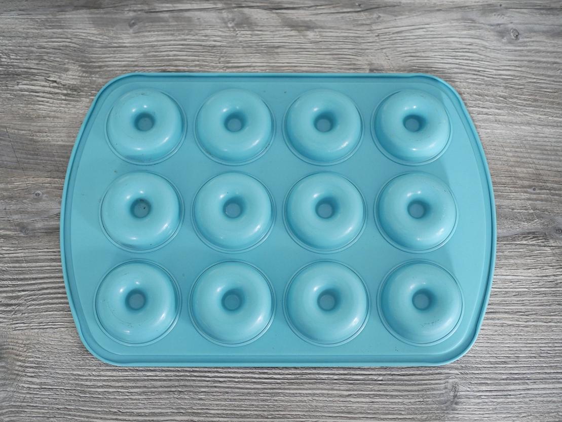 Backform mit 12 Mulden in Donutform von Pampered Chef, auf grauer Arbeitsplatte, Unterseiten Ansicht