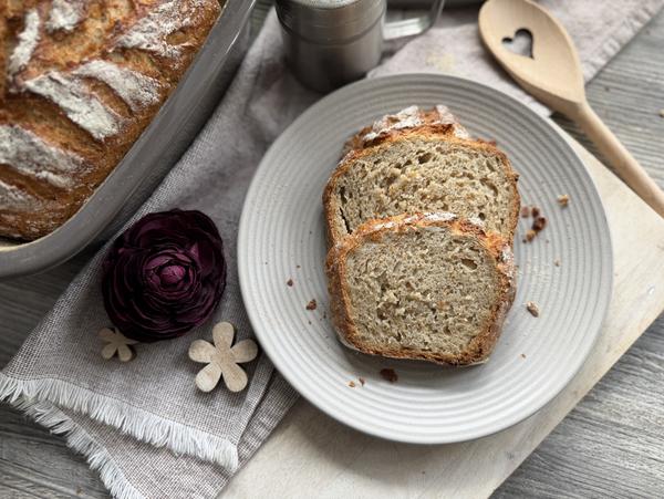 Haferbrot Rezept – Brotscheiben von oben Haferbrot-Scheiben auf grauem Teller von oben, daneben das Brot im Kleinen Ofenmeister von Pampered Chef®