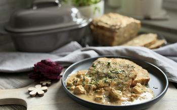 Semmelknödel mit Soße auf Teller angerichtet im Hintergrund kleiner Ofenmeister von Pampered Chef® 