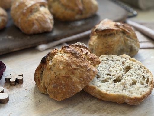 Chia-Knaller Rezept - angerichtet Aufgeschnittenes Brötchen auf Teller - im Hintergrund Brötchen auf Zauberstein