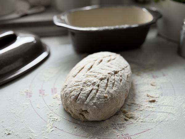 Haferbrot Rezept – Brotlaib formen und einschneiden Eingeschnittener Haferbrot-Laib auf der bemehlten Teigunterlage von Pampered Chef®