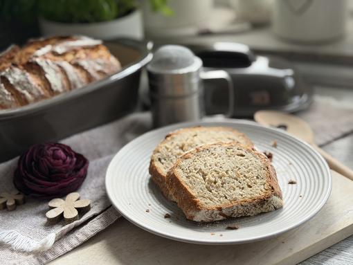 Haferbrot Rezept – Brotscheiben angerichtet Zwei Scheiben Haferbrot mit lockerer Krume auf weißem Teller, dahinter der Kleine Ofenmeister