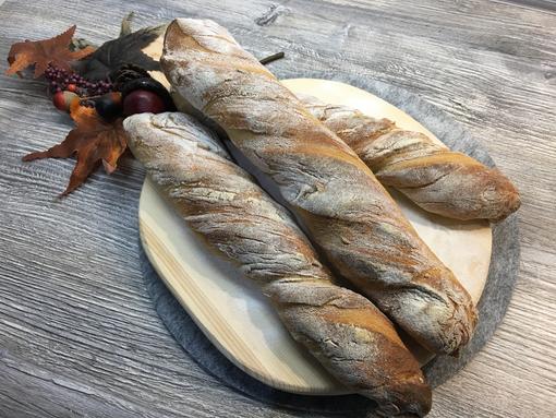 Französisches Baguette auf Holzbrett auf dem Zauberstein gebacken